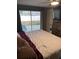 Bedroom featuring a sliding glass door to the backyard and a large bed with neutral-colored bedding at 3612 Devonshire Dr, Holiday, FL 34691