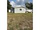 A single-story home's side exterior shows neutral colors with a well-kept lawn, offering a clean and inviting appearance at 3612 Devonshire Dr, Holiday, FL 34691