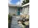 Charming front porch with chairs, a welcome sign, and a teal front door at 3612 Devonshire Dr, Holiday, FL 34691