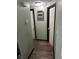 Hallway with wood floors, featuring access to multiple rooms and providing functional transition throughout the home at 3612 Devonshire Dr, Holiday, FL 34691