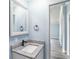 Bathroom with granite countertop vanity and black hardware, light blue walls and light wood-look flooring at 3924 Kiah Dr, Wesley Chapel, FL 33543