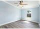 Bedroom features light blue walls, a ceiling fan, light wood-look flooring, and a bright window at 3924 Kiah Dr, Wesley Chapel, FL 33543