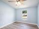 Bedroom featuring light blue walls, light wood-look flooring, and a bright window at 3924 Kiah Dr, Wesley Chapel, FL 33543