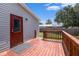 Exterior view of a wooden deck with a red door and gray siding on the home at 3924 Kiah Dr, Wesley Chapel, FL 33543