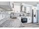 Modern kitchen featuring white cabinetry, stainless steel appliances, and speckled granite countertops at 3924 Kiah Dr, Wesley Chapel, FL 33543