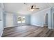 Bright living room with modern ceiling fan, gray floors, complemented by calming light blue walls and white trim at 3924 Kiah Dr, Wesley Chapel, FL 33543