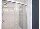 Modern glass shower with white tile surround and decorative accent tiles at 3924 Kiah Dr, Wesley Chapel, FL 33543