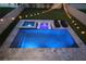 Aerial view of a swimming pool and jacuzzi that is lit with blue lighting, with lounge chairs and landscaping at 4115 N Blvd, Tampa, FL 33603