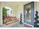 Inviting front porch featuring decorative tiling, an accent tree, and a relaxing porch swing at 4115 N Blvd, Tampa, FL 33603