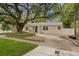 Inviting single story home featuring mature landscaping, a shade tree and a blue front door at 4121 W San Nicholas St, Tampa, FL 33629