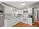 Contemporary kitchen featuring white cabinets, granite countertops, and hardwood floors at 4150 Pecos Dr, New Port Richey, FL 34653