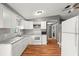 Bright kitchen features white cabinets, stainless appliances, tile backsplash and wood floors at 4150 Pecos Dr, New Port Richey, FL 34653