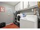 Indoor laundry room features a washing machine and dryer with storage cabinets at 4150 Pecos Dr, New Port Richey, FL 34653
