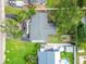 An aerial view of the home showing the roof, landscaping, detached garage, and nearby pool at 4461 Shore Acres Ne Blvd, St Petersburg, FL 33703