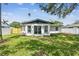 The back of the house shows a well maintained lawn, large glass doors, and fresh white paint at 4461 Shore Acres Ne Blvd, St Petersburg, FL 33703