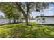 Spacious backyard with a pergola, mature tree, and white vinyl privacy fence at 4461 Shore Acres Ne Blvd, St Petersburg, FL 33703