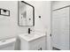 Bathroom with vanity, white walls, matte black hardware, and storage closet at 4461 Shore Acres Ne Blvd, St Petersburg, FL 33703