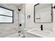 Bathroom with modern fixtures, including black shower head and white-marbled tiles at 4461 Shore Acres Ne Blvd, St Petersburg, FL 33703