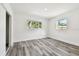 Bedroom with two windows, gray wood flooring, and white paint at 4461 Shore Acres Ne Blvd, St Petersburg, FL 33703