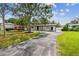 Exterior shot showing a white single-story home with landscaping, driveway, and lawn at 4461 Shore Acres Ne Blvd, St Petersburg, FL 33703