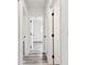 Hallway with interior doors, grey wood floors and white walls at 4461 Shore Acres Ne Blvd, St Petersburg, FL 33703