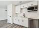 Updated kitchen features white cabinetry, stainless steel appliances, and wood-look flooring at 4461 Shore Acres Ne Blvd, St Petersburg, FL 33703