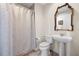 Bathroom featuring a white pedestal sink, toilet, decorative mirror and shower at 449 S 12Th St # 1201, Tampa, FL 33602