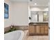 Bathroom showcasing a soaking tub, tiled surround, and a vanity with ample storage at 449 S 12Th St # 1201, Tampa, FL 33602