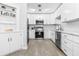 Modern kitchen with white cabinets, stainless steel appliances, and a decorative 'Let's Eat' sign on a built-in shelf at 4531 7Th N Ave, St Petersburg, FL 33713