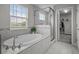Bright bathroom featuring a soaking tub, glass shower, and view of the outdoors at 4770 Ballantrae Blvd, Land O Lakes, FL 34638