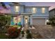 Beautiful blue two-story home with an inviting front porch, complemented by lush landscaping and a two car garage at 4770 Ballantrae Blvd, Land O Lakes, FL 34638