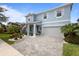 Attractive blue two-story home with landscaped front yard and a gray brick paved driveway at 4770 Ballantrae Blvd, Land O Lakes, FL 34638