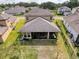 Aerial of the backyard and covered lanai with seating and dark metal privacy fence at 4916 Rolling Green Dr, Wesley Chapel, FL 33543