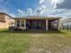 Home backyard featuring a covered patio, lawn, and fence, creating a private outdoor space at 4916 Rolling Green Dr, Wesley Chapel, FL 33543