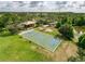 Aerial view of community basketball court, surrounded by green space, shade, and landscaping at 4916 Rolling Green Dr, Wesley Chapel, FL 33543