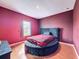 Bedroom featuring a unique round bed, wood flooring, and a window with natural light at 4916 Rolling Green Dr, Wesley Chapel, FL 33543