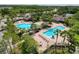 Aerial view of a community pool area, complete with lounge chairs and lush landscaping at 4916 Rolling Green Dr, Wesley Chapel, FL 33543