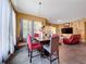A dining room featuring an elegant wood table with colorful chairs and views into the living room at 4916 Rolling Green Dr, Wesley Chapel, FL 33543