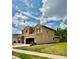 Two-story home featuring a two-car garage, neutral paint, and manicured lawn under a partly cloudy sky at 4916 Rolling Green Dr, Wesley Chapel, FL 33543
