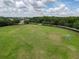 Aerial view of a large grassy field with soccer goals, surrounded by mature trees at 4916 Rolling Green Dr, Wesley Chapel, FL 33543