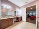 En-suite bathroom boasting double vanity, tiled floors, granite counters, and a tub/shower combo at 4916 Rolling Green Dr, Wesley Chapel, FL 33543