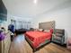 Bright primary bedroom with hardwood floors, a decorative window and a stylish seating area at 4916 Rolling Green Dr, Wesley Chapel, FL 33543