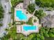 Aerial view of the community pool featuring a large pool, pool, lounge chairs and mature landscaping at 4916 Rolling Green Dr, Wesley Chapel, FL 33543