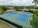 Aerial view of well-maintained community tennis courts with green and blue surfaces at 4916 Rolling Green Dr, Wesley Chapel, FL 33543