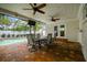 Covered patio featuring brick floors, ceiling fans, a dining table, and access to the pool at 5005 W Evelyn Dr, Tampa, FL 33609
