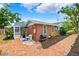 Back exterior view of brick home with brick walkway and partial screened in area at 509 Falmouth St, Temple Terrace, FL 33617