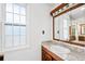 Bathroom featuring a wood vanity with granite countertop and a large window at 509 Falmouth St, Temple Terrace, FL 33617
