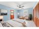 Light and airy bedroom with tile floors, blue walls, white chairs and ceiling fan at 509 Falmouth St, Temple Terrace, FL 33617