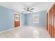Spacious bedroom features tile floors, a ceiling fan and a door to the backyard at 509 Falmouth St, Temple Terrace, FL 33617