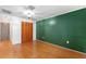 Bedroom features wood floors, a large closet, and green accent wall at 509 Falmouth St, Temple Terrace, FL 33617